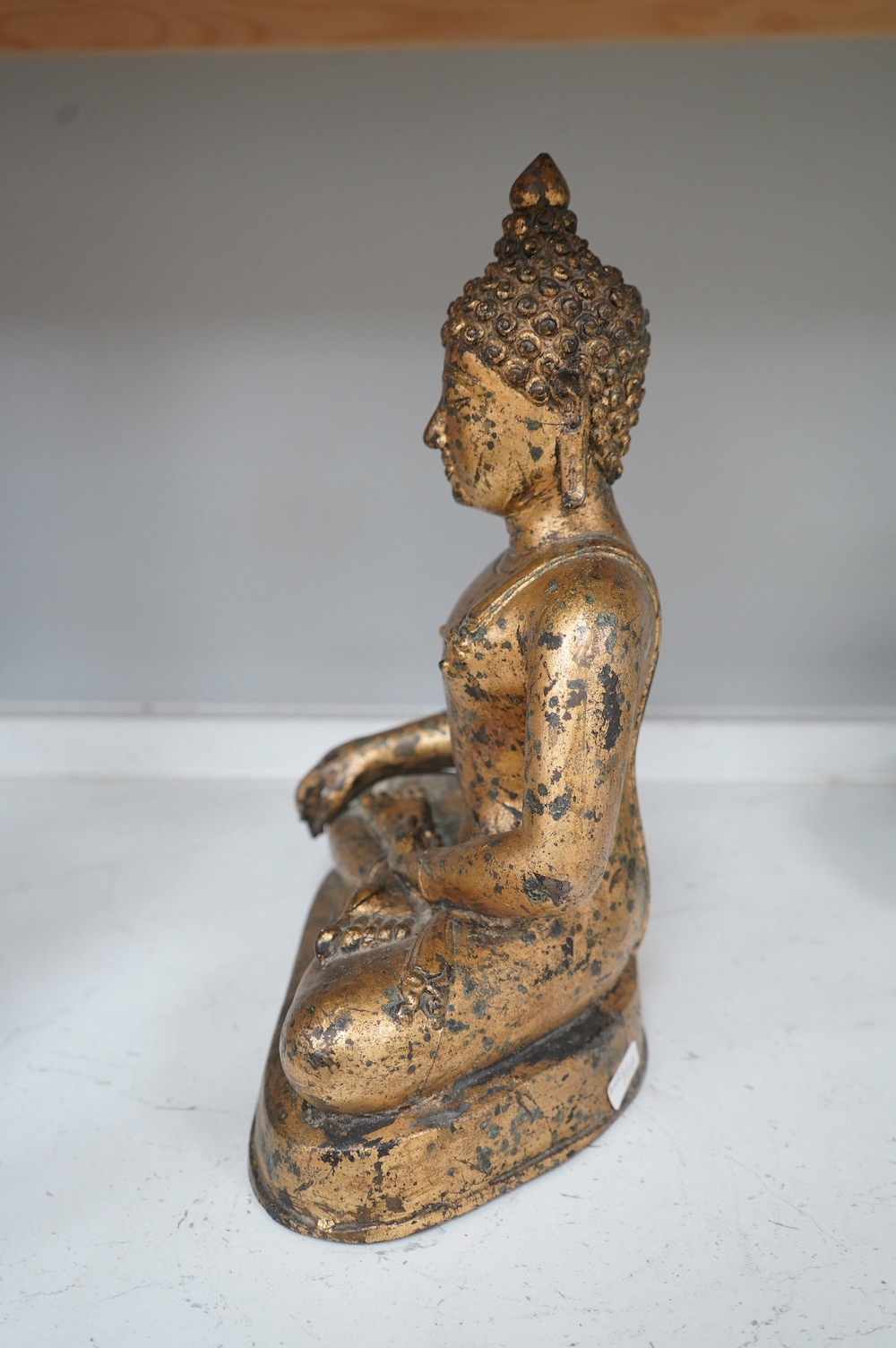 A Chinese gilt bronze figure of seated Buddha, 33cm high. Condition - fair, some holes